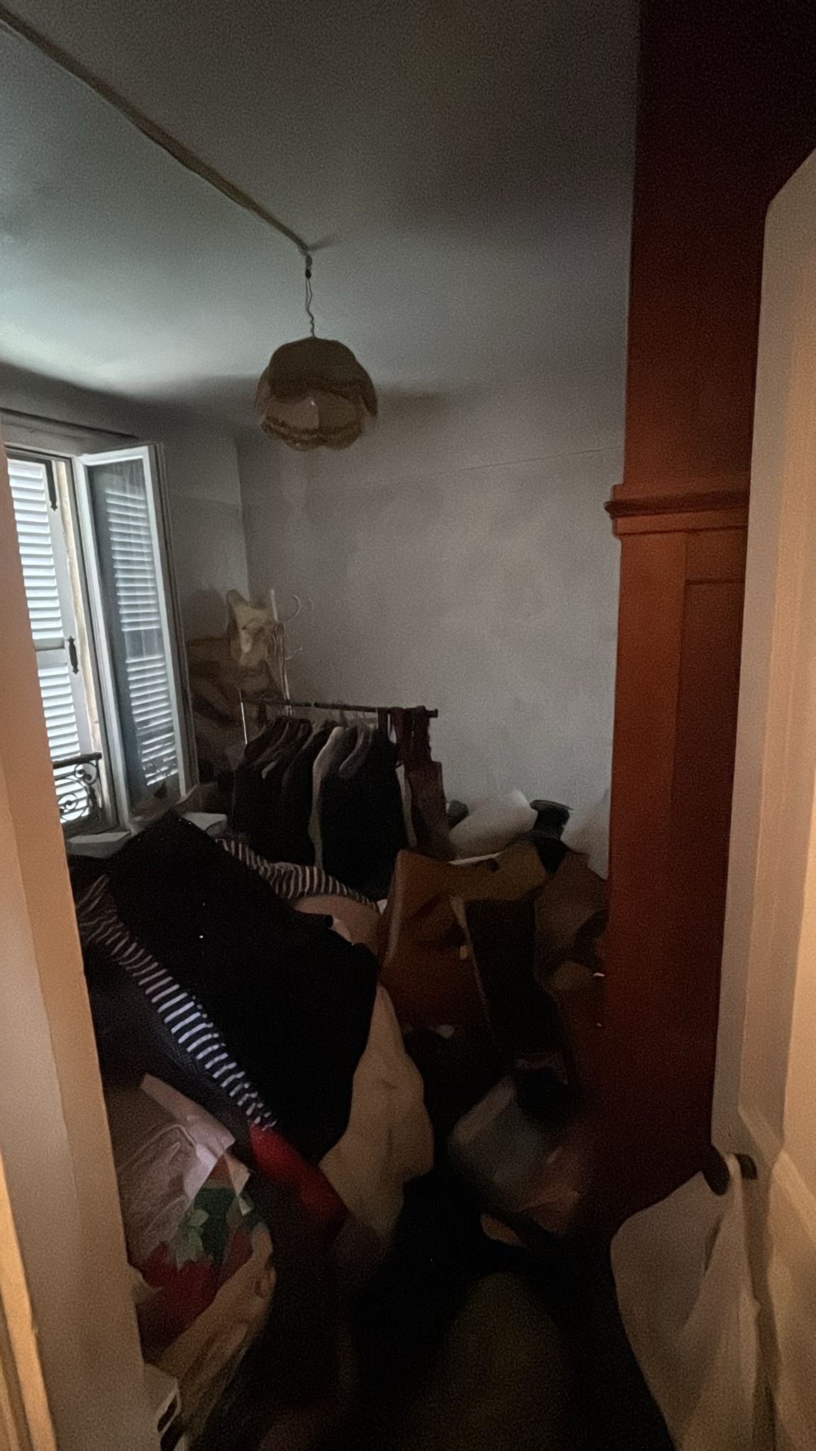 Intervenant en tenue de protection préparant le nettoyage d'un logement encombré
