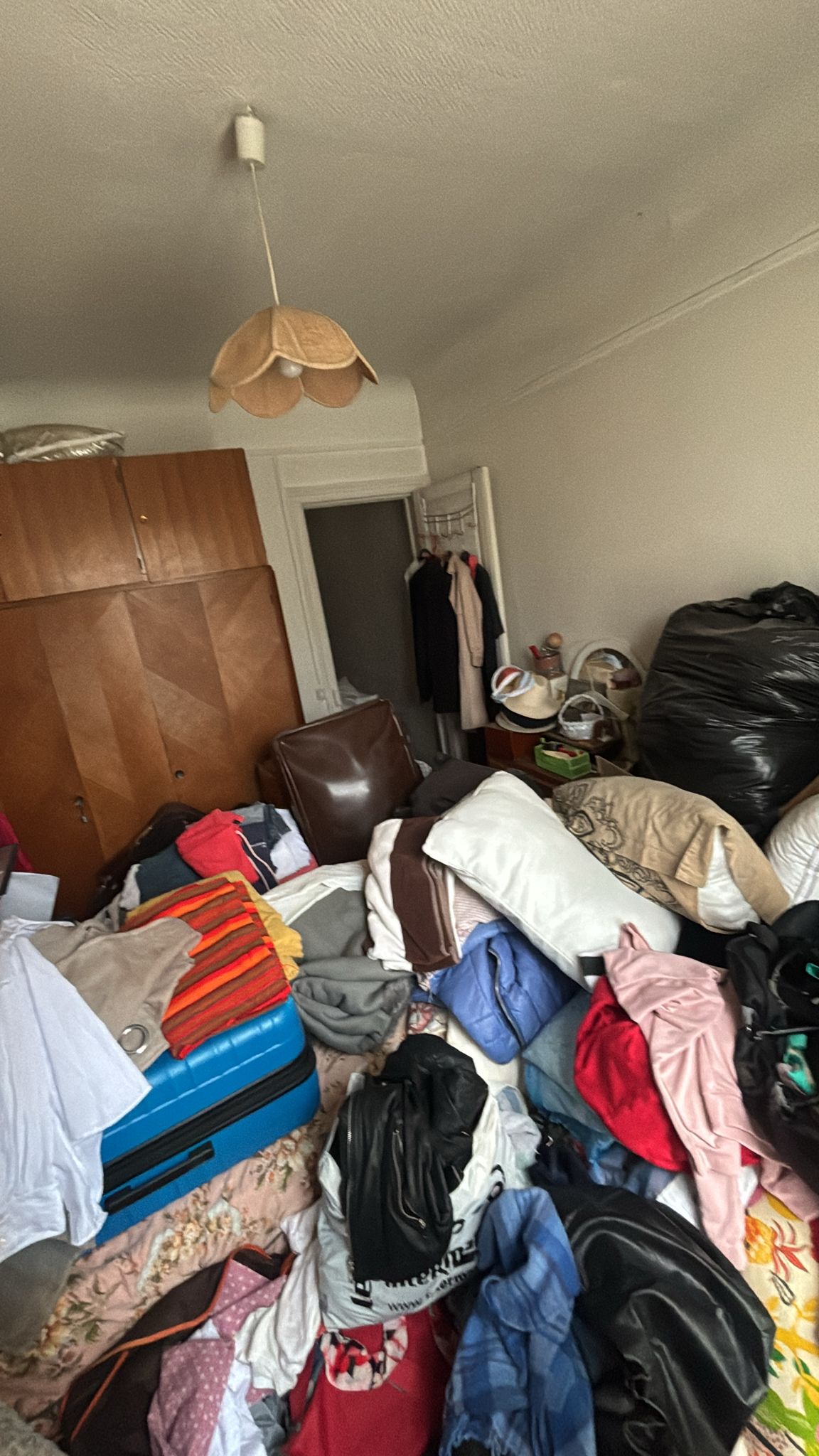 Intervenant en équipement de protection observant un logement encombré avant nettoyage
